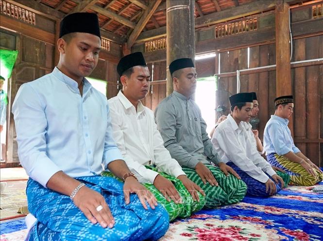 Những người đàn ông Chăm Islam mặc trang phục truyền thống, cùng nhau đến thánh đường thực hiện nghi lễ cầu nguyện. Ảnh: Khánh Hoà - TTXVN
