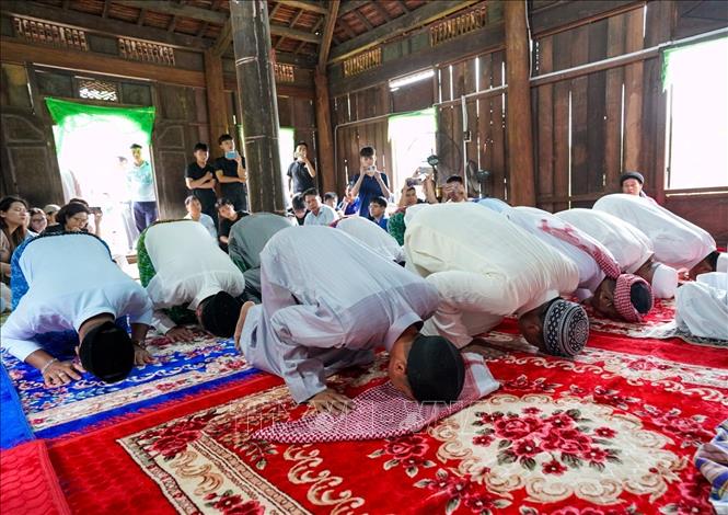 Những người đàn ông Chăm Islam mặc trang phục truyền thống, cùng nhau đến thánh đường thực hiện nghi lễ cầu nguyện. Ảnh: Khánh Hoà - TTXVN