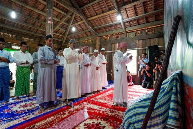 Những người đàn ông Chăm Islam mặc trang phục truyền thống, cùng nhau đến thánh đường thực hiện nghi lễ cầu nguyện. Ảnh: Khánh Hoà - TTXVN