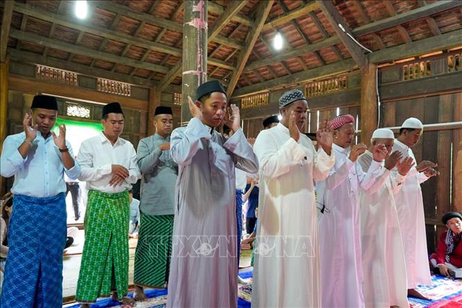 Những người đàn ông Chăm Islam mặc trang phục truyền thống, cùng nhau đến thánh đường thực hiện nghi lễ cầu nguyện. Ảnh: Khánh Hoà - TTXVN