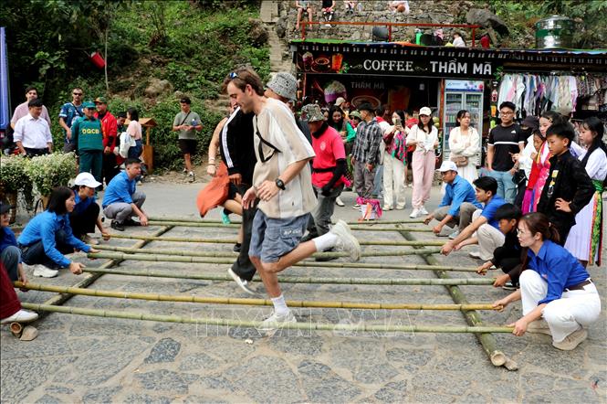 Du khách nước ngoài hào hứng nhảy sạp cùng các em học sinh tại dốc Thẩm Mã, trải nghiệm nét văn hóa truyền thống của đồng bào các dân tộc trên Cao nguyên đá. Ảnh: Đức Thọ - TTXVN