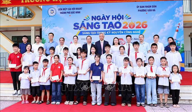 Các đại biểu trao quà cho học sinh có thành tích học tập xuất sắc trên địa bàn phường Vân Hà. Ảnh: Đồng Thúy - TTXVN
