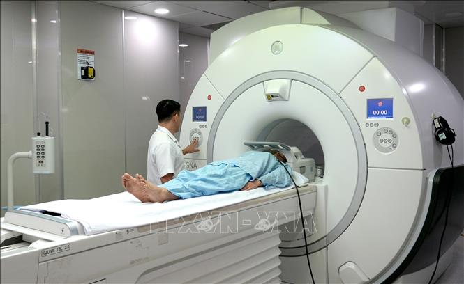 Bác sĩ, kĩ thuật viên Bệnh viện Hữu nghị đa khoa Nghệ An thực hiện chụp cộng hưởng từ (MRI) 3.0T. Ảnh: Văn Tý-TTXVN