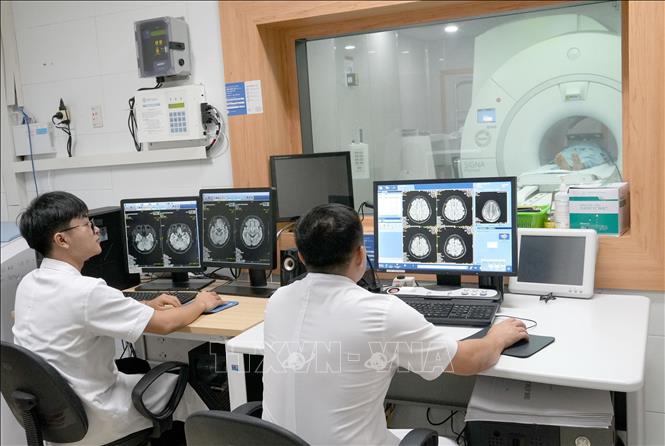 Bác sĩ, kĩ thuật viên Bệnh viện Hữu nghị đa khoa Nghệ An thực hiện chụp cộng hưởng từ (MRI) 3.0T. Ảnh: Văn Tý-TTXVN