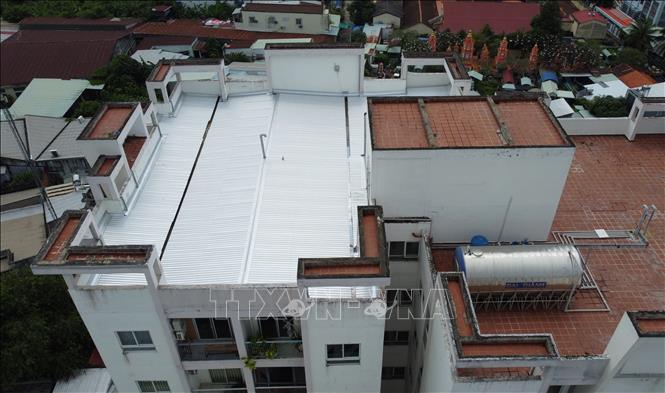 Vì không thể chịu cảnh bị dột mưa trong thời gian dài, chủ căn hộ đã bỏ tiền ra để lợp tôn một phần sân thượng nhằm chống thấm dột khi có mưa. Ảnh: Nhựt An - TTXVN
