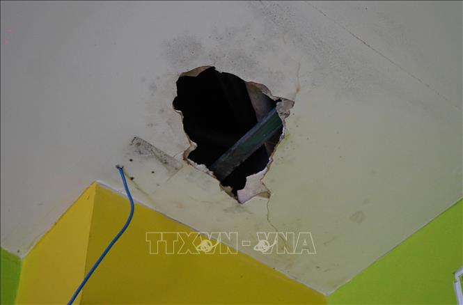 Vì bị thấm dột nước trong thời gian dài nên trần nhà bị thủng. Ảnh: Nhựt An - TTXVN