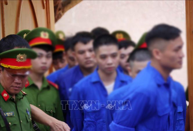 Dẫn giải các bị cáo vào phòng xét xử tại điểm cầu hội trường Trại tạm giam số 1 (Công an Hà Nội). Ảnh: Văn Điệp – TTXVN