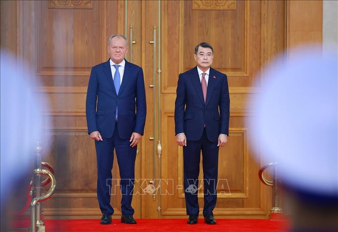 Thủ tướng Lê Minh Hưng và Thủ tướng Ba Lan Donald Tusk thực hiện nghi lễ chào cờ. Ảnh: Dương Giang – TTXVN 