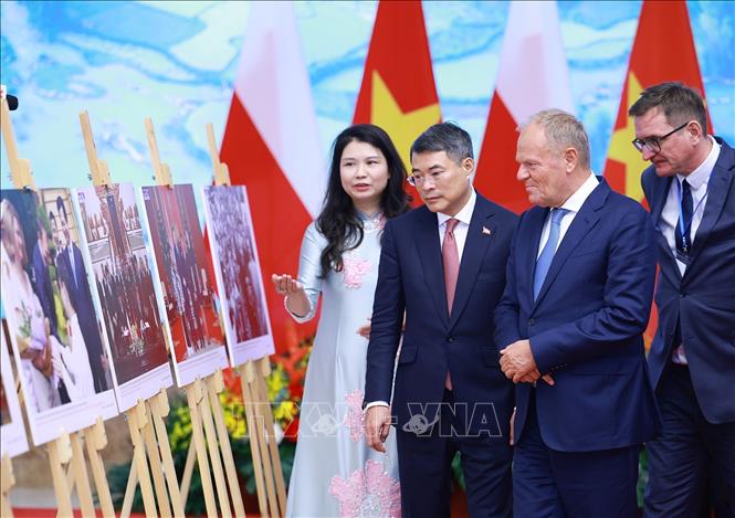 Thủ tướng Lê Minh Hưng và Thủ tướng Cộng hòa Ba Lan Donald Tusk tham quan trưng bày ảnh về quan hệ hợp tác hai nước do Thông tấn xã Việt Nam thực hiện. Ảnh: Dương Giang – TTXVN 
