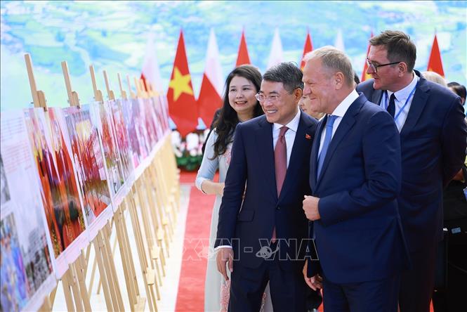 Thủ tướng Lê Minh Hưng và Thủ tướng Cộng hòa Ba Lan Donald Tusk tham quan trưng bày ảnh về quan hệ hợp tác giữa hai nước do Thông tấn xã Việt Nam thực hiện. Ảnh: Dương Giang – TTXVN 
