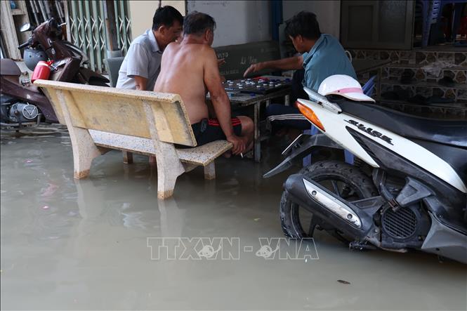 Người dân hẻm 1632 đường Huỳnh Tấn Phát, xã Nhà Bè, sống chung với ngập khi triều cường lên cao. Ảnh: Hồng Đạt - TTXVN