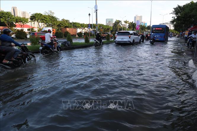 Triều cường gây ngập một đoạn dài trên đường Nguyễn Văn Linh, phường Tân Thuận, chiều 26/10. Ảnh: Hồng Đạt - TTXVN