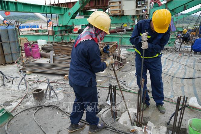 Công nhân gấp rút thi công mặt cầu. Ảnh: Hồng Ninh - TTXVN