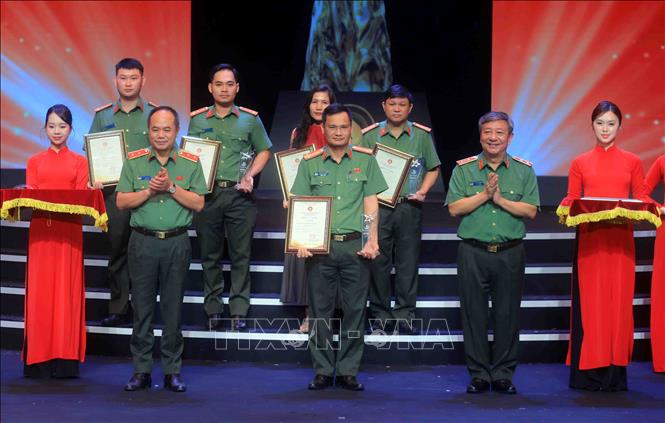 Trung tướng Đỗ Triệu Phong, Cục trưởng Cục Truyền thông Công an nhân dân và Trung tướng Nguyễn Thanh Tùng, Giám đốc Công an thành phố Hà Nội trao giải Bạc cho các tác giả đạt giải. Ảnh: Phạm Kiên - TTXVN