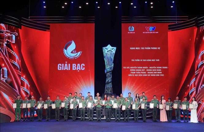 Trung tướng Đỗ Triệu Phong, Cục trưởng Cục Truyền thông Công an nhân dân và Trung tướng Nguyễn Thanh Tùng, Giám đốc Công an thành phố Hà Nội trao giải Bạc cho các tác giả đạt giải. Ảnh: Phạm Kiên - TTXVN