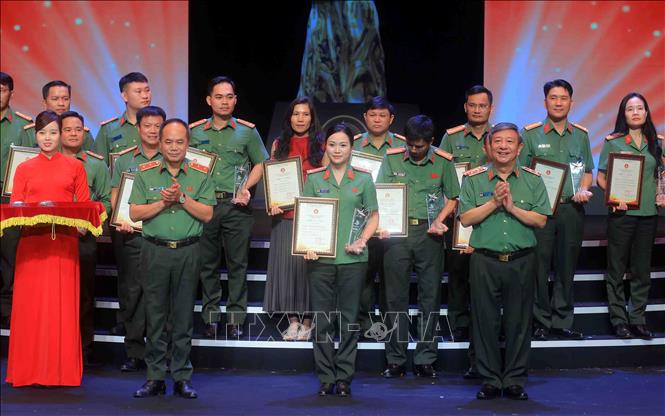 Trung tướng Đỗ Triệu Phong, Cục trưởng Cục Truyền thông Công an nhân dân và Trung tướng Nguyễn Thanh Tùng, Giám đốc Công an thành phố Hà Nội trao giải Bạc cho các tác giả đạt giải. Ảnh: Phạm Kiên - TTXVN