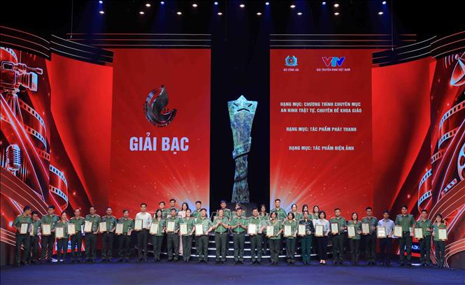 Thiếu tướng Nguyễn Ngọc Quyền, Phó Giám đốc Công an thành phố Hà Nội và Đại tá Nguyễn Anh Tuấn, Phó Cục trưởng Cục Truyền thông Công an nhân dân trao giải Bạc cho các tác giả đạt giải. Ảnh: Phạm Kiên - TTXVN