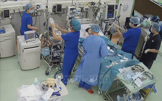 Bác sĩ Bệnh viện Nhi đồng 1 thiếp lập hệ thống ECMO hỗ trợ tim mạch cho bệnh nhi. Ảnh: TTXVN phát