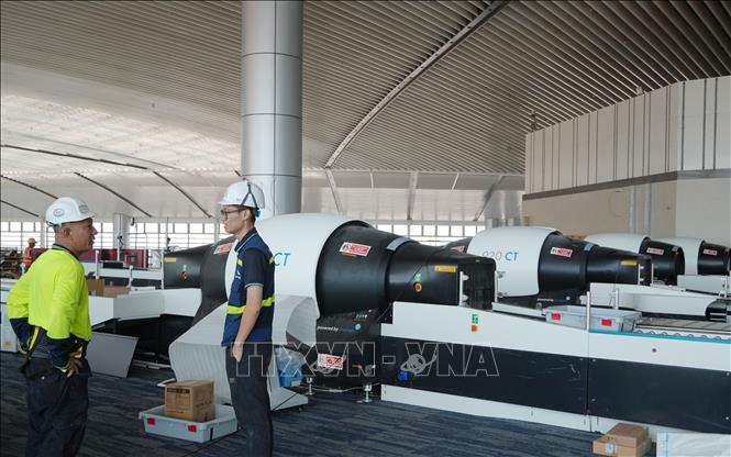 Chuyên gia nước ngoài và kỹ sư Việt Nam trao đổi trong quá trình lắp đặt máy soi chiếu hành lý 3D tại nhà ga hành khách sân bay Long Thành. Ảnh: Công Phong - TTXVN