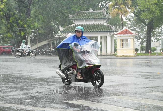 Người dân đi lại trong mưa lớn ở trung tâm thành phố Huế. Ảnh: Nguyên Lý - TTXVN