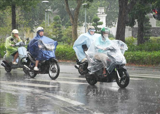 Người dân đi lại trong mưa lớn trên đường Lê Lợi, phường Thuận Hóa, thành phố Huế. Ảnh: Nguyên Lý - TTXVN