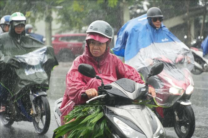 Người dân đi lại trong mưa lớn ở trung tâm thành phố Huế. Ảnh: Nguyên Lý - TTXVN