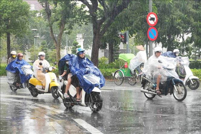 Người dân đi lại trong mưa lớn trên đường Lê Lợi, phường Thuận Hóa, thành phố Huế. Ảnh: Nguyên Lý - TTXVN
