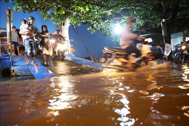Việc lên xuống phà Bến Đá ẩn chứa nhiều nguy hiểm cho hành khách do nước ngập, trơn trượt. Ảnh: Hồng Đạt - TTXVN