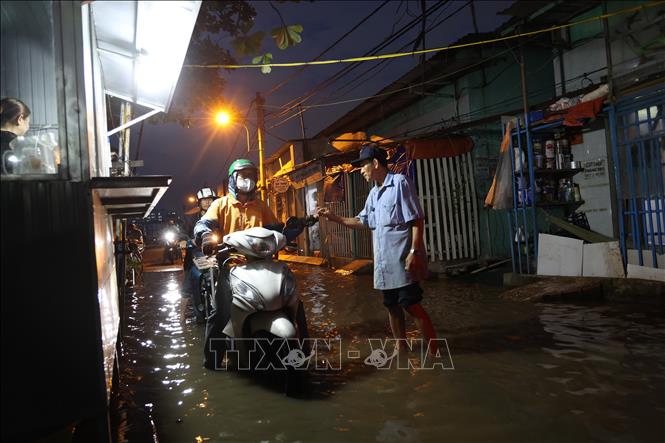 Triều cường lên cao gây khó khăn cho người dân trong sinh hoạt hằng ngày. Ảnh: Hồng Đạt - TTXVN