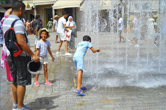Người dân tránh nóng bên đài phun nước ở Tunis, Tunisia. Ảnh: THX/TTXVN phát