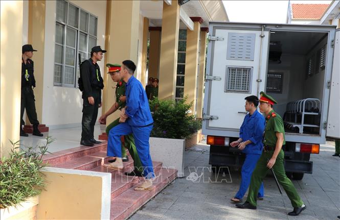 Lực lượng Công an dẫn giải các bị cáo vào hội trường để chuẩn bị xét xử. Ảnh: Hữu Chí - TTXVN