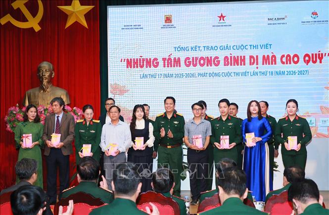 Ban tổ chức tặng sách “Những tấm gương bình dị mà cao quý”cho các đại biểu. Ảnh: Trọng Đức - TTXVN.