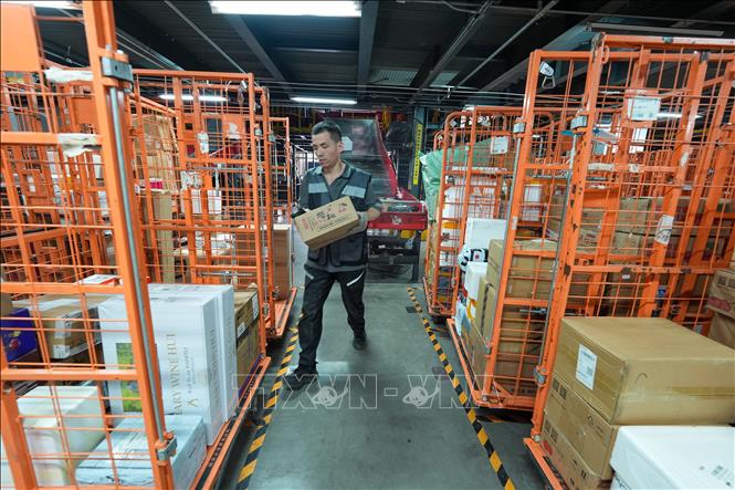 Nhân viên phân loại bưu kiện tại một trung tâm giao nhận ở Bắc Kinh, Trung Quốc. Ảnh: THX/TTXVN phát