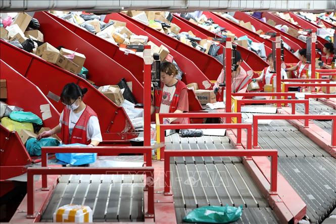 Nhân viên làm việc tại dây chuyền phân loại bưu kiện của một công ty chuyển phát nhanh ở tỉnh Giang Tô, Trung Quốc. Ảnh: THX/TTXVN phát
