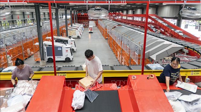 Nhân viên làm việc tại dây chuyền phân loại bưu kiện của một trung tâm điều phối phương tiện tự hành thông minh ở tỉnh Giang Tô, Trung Quốc. Ảnh: THX/TTXVN phát