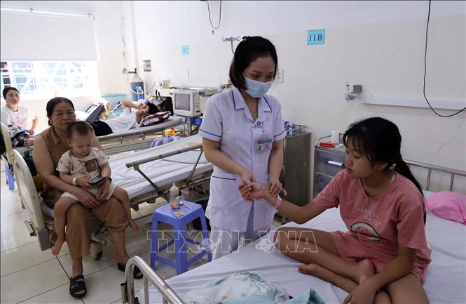 Nhân viên y tế chăm sóc, theo dõi bệnh nhi đang điều trị sốt xuất huyết tại khoa Y học nhiệt đới Nhi – Hồi sức tích cực và bệnh lý, Bệnh viện Phụ sản – Nhi Đà Nẵng. Ảnh: Trần Lê Lâm - TTXVN 