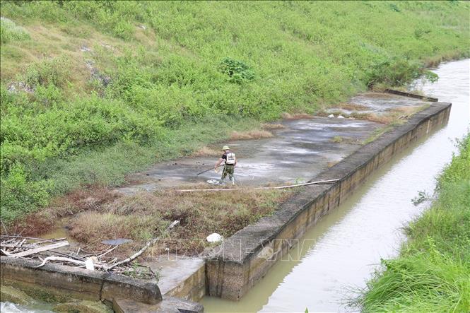 Người dân đánh bắt bằng kích điện trên thân cống hộp cống Hiệp Hòa (xã Văn Hiến, tỉnh Nghệ An). Ảnh: Xuân Tiến - TTXVN 