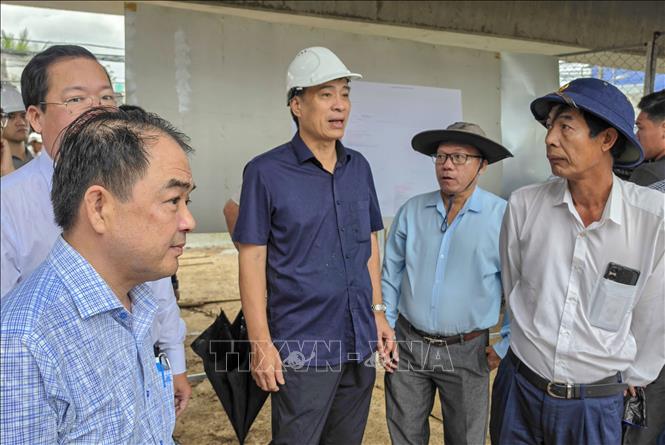 Thứ trưởng Bộ Xây dựng Phạm Minh Hà (giữa) kiểm tra tiến độ thi công nâng tĩnh không cầu Ô Môn (Cần Thơ). Ảnh: Thanh Liêm - TTXVN