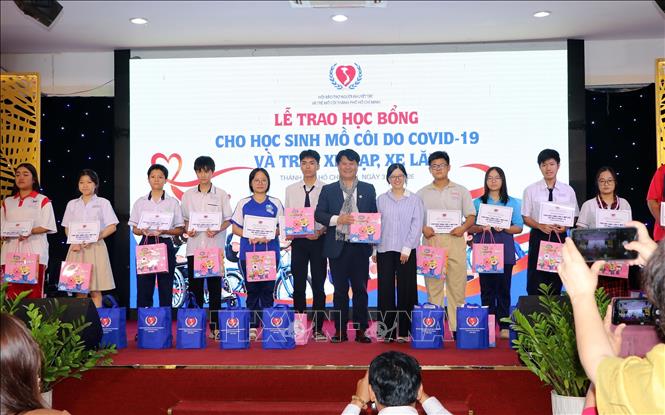 Đại diện các đơn vị doanh nghiệp, nhà tài trợ trao học bổng cho các trẻ mồ côi. Ảnh: Thanh Vũ - TTXVN
