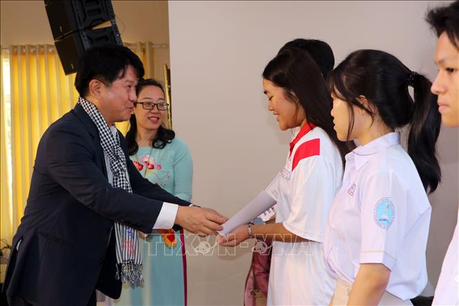 Đại diện các đơn vị doanh nghiệp, nhà tài trợ trao học bổng cho trẻ mồ côi. Ảnh: Thanh Vũ - TTXVN

