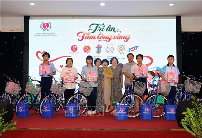 Đại diện các đơn vị doanh nghiệp, nhà tài trợ trao tặng xe đạp cho trẻ có hoàn cảnh khó khăn. Ảnh: Thanh Vũ - TTXVN
