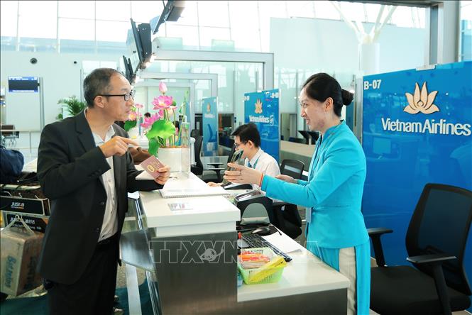 Du khách nước ngoài làm thủ tục check-in tại quầy của Vietnam Airlines tại nhà ga T2 sân bay quốc tế Nội Bài. Ảnh: Quốc Khánh - TTXVN