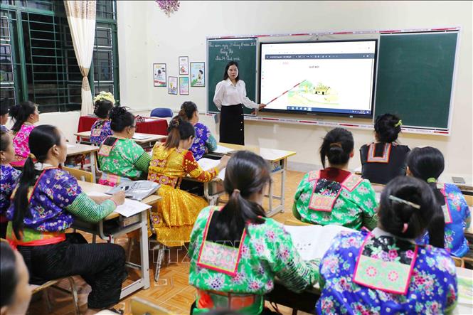 Giáo viên sử dụng thiết bị dạy học hiện đại kết hợp phương pháp giảng dạy trực quan, giúp học viên dễ tiếp thu kiến thức, nâng cao hiệu quả lớp học xóa mù chữ. Ảnh: Trung Kiên - TTXVN