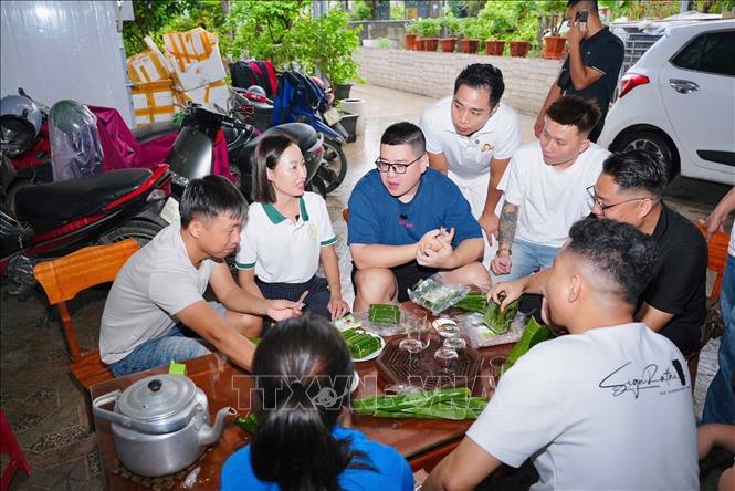 Nhóm các nhà sáng tạo nội dung số đến tìm hiểu, quay phim quảng bá tại Cơ sở nem chua OCOP Ý Bình. Ảnh: Hoàng Ngà - TTXVN