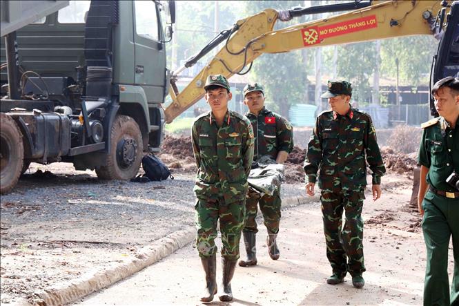 Cán bộ, chiến sĩ Đội K74 di chuyển di cốt liệt sĩ tới khu vực lấy mẫu. Ảnh (tư liệu): Xuân Khu-TTXVN